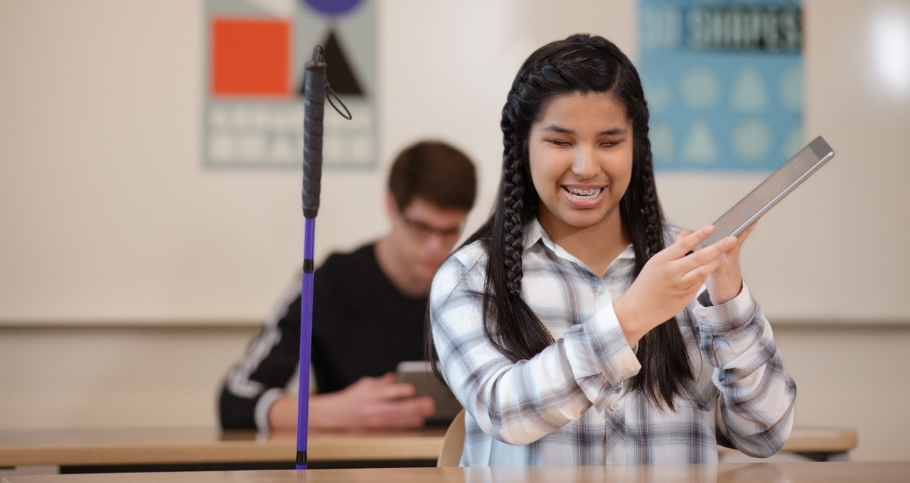 190209_EDU_HighSchool-San-Mateo_DeanneFitzmaurice Eine Gruppe von vier Schülern und Schülerinnen sitzt mit einem iPad vor einer Schrankwand.